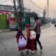 Humanis! Kapolsek Telukjambe Barat Gandeng Bocah Sekolah Menyeberang di Jalan Raya Badami-Loji